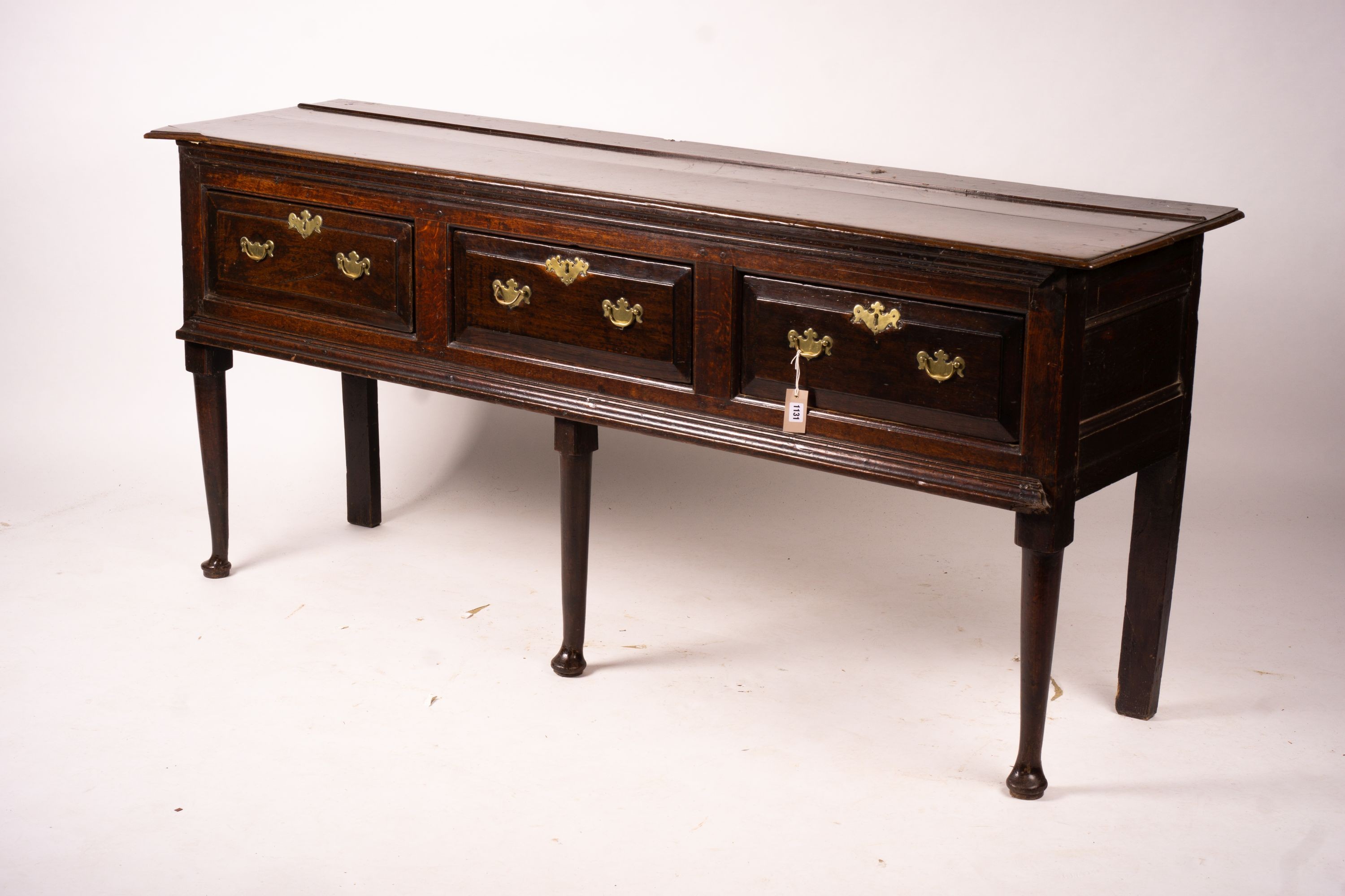 An 18th century oak low dresser on pole turned legs and pad feet, length 198cm, depth 53cm, height 88cm